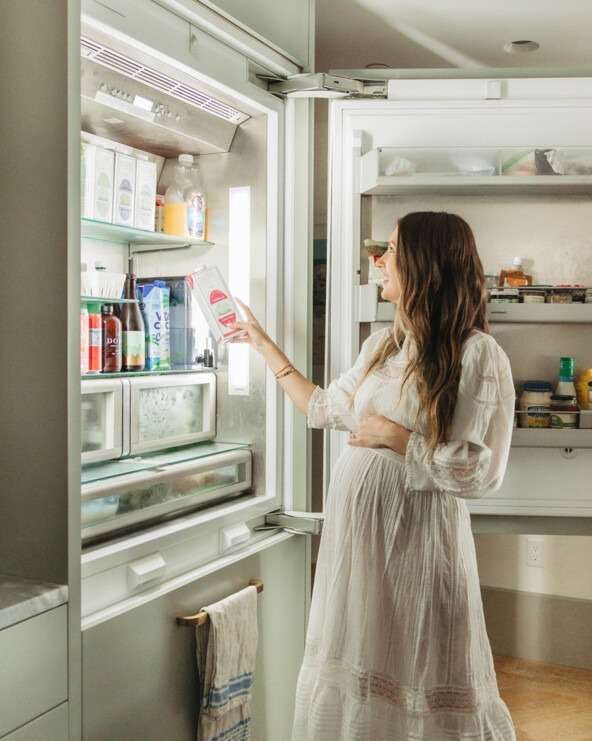 Woman reaching into fridge